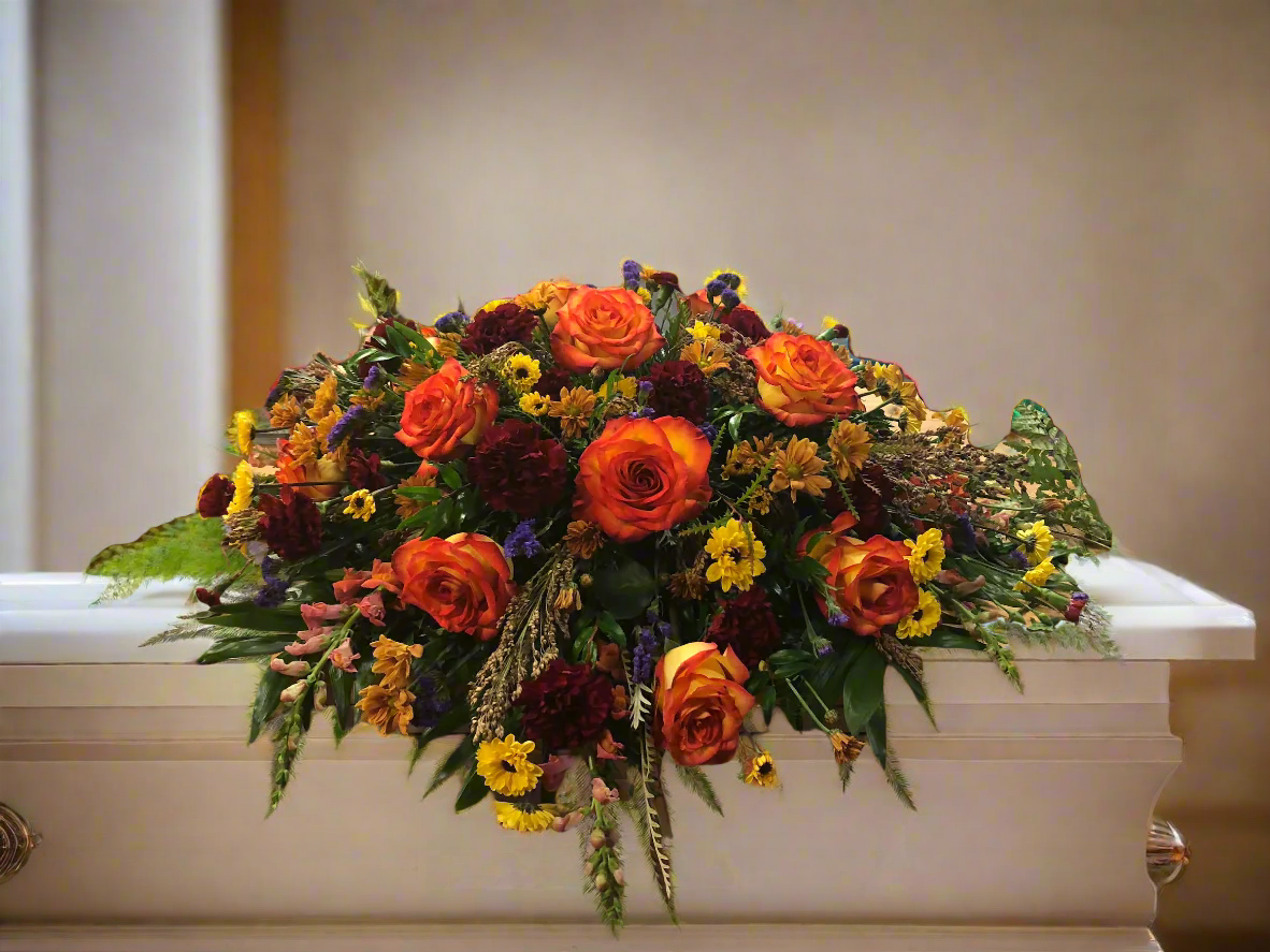 Colorful floral spray on a casket in a church setting