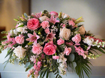 Monochromatic pink and white floral spray for funeral casket